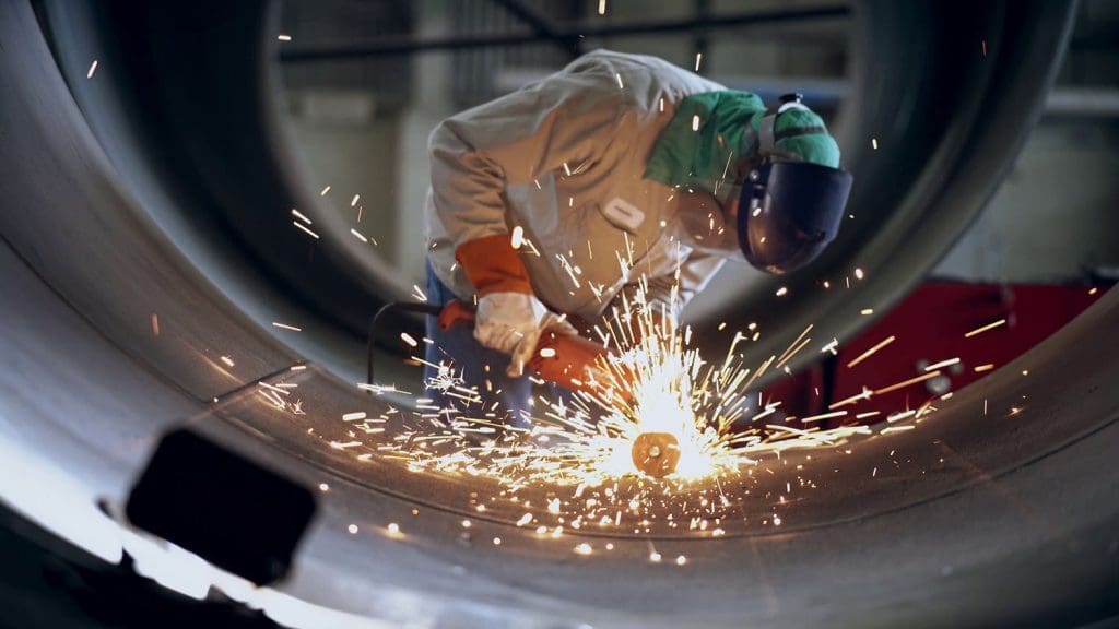 A person welding what will become the inside of a pressure vessel.