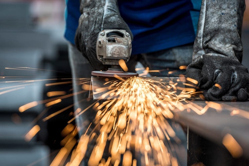a person sanding down a corner of a weld